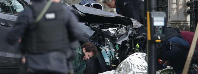 London - Foto: Polizisten untersuchen in der Nähe des Londoner Parlaments ein Auto, mit dem mehrere Menschen überfahren worden sein sollen. Foto: Yui Mok
